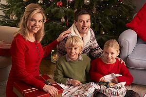 Family Opening Christmas Gifts At Home