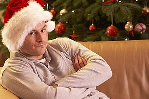 Man Relaxing In Front Of Christmas Tree