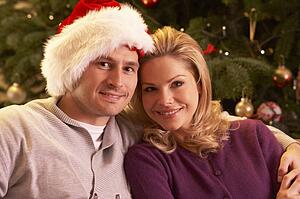 Couple Relaxing In Front Of Christmas Tree