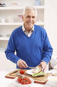Senior Man Making Sandwich In Kitchen