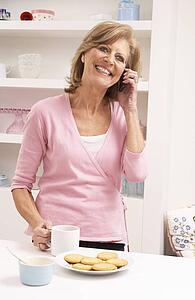 Senior Woman Enjoying Hot Drink Whilst On Phone