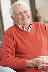 Senior Man Relaxing In Chair At Home