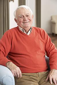 Senior Man Relaxing In Chair At Home