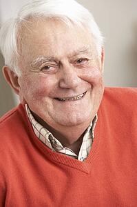 Senior Man Relaxing In Chair At Home