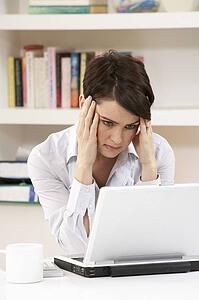Worried Looking Woman Working From Home Using Laptop