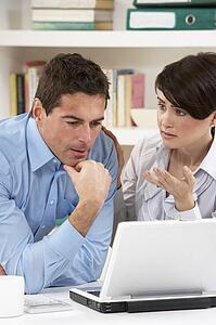 Worried Couple Working From Home Using Laptop