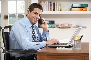 Man Working From Home Using Laptop On Phone