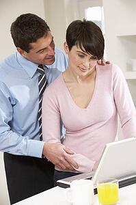 Couple Working From Home Using Laptop