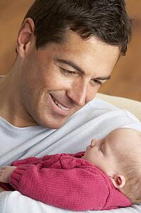 Portrait Of Father With Newborn Baby At Home