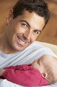 Portrait Of Father With Newborn Baby At Home