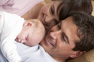 Portrait Of Proud Parents With Newborn Baby At Home