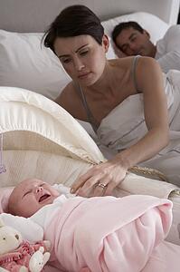 Newborn Baby Crying In Cot In Parents Bedroom