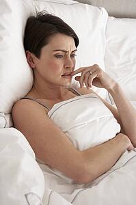 Worried Woman Laying Awake In Bed