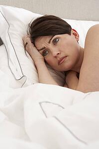 Worried Woman Laying Awake In Bed
