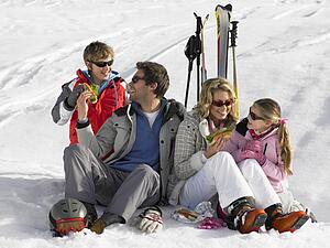 Young Family Sharing A Picnic On Ski Vacation