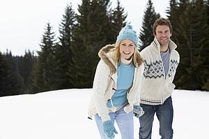 Young Couple In Alpine Snow Scene