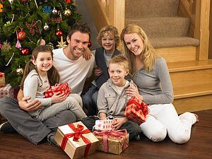 Family with gifts in front of Christmas tree