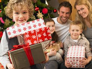 Family with gifts in front of Christmas tree