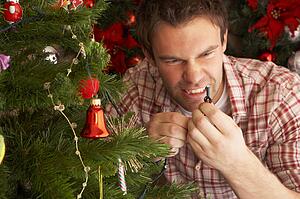 Young man trying to fix Christmas tree lights