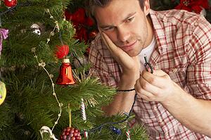Young man trying to fix Christmas tree lights