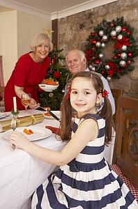 Child having Christmas dinner with grandparents