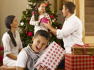 Hispanic family exchanging gifts at Christmas