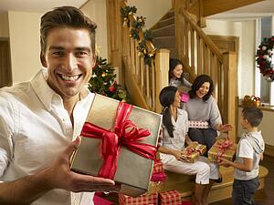 Hispanic family exchanging gifts at Christmas