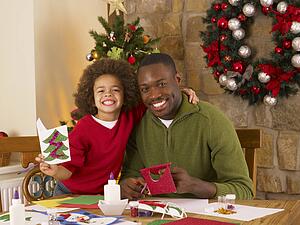 African American father and mixed race son making Christmas cards