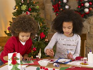Mixed race children making Christmas cards