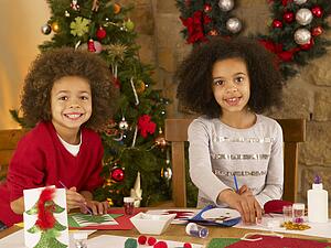 Mixed race children making Christmas cards