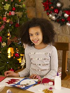 Mixed race child making Christmas cards