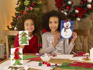Mixed race children making Christmas cards