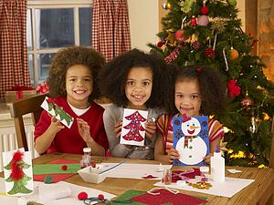 Mixed race children making Christmas cards