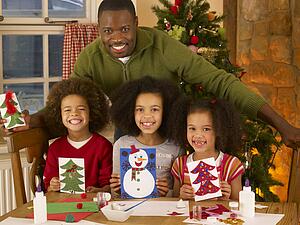 African American father making Christmas cards with children