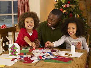 African American father making Christmas cards with children