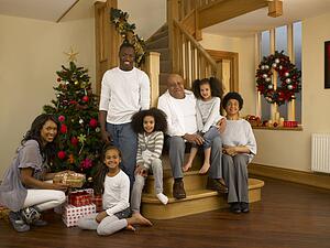 Mixed race family with Christmas tree and gifts