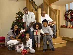 Mixed race family with Christmas tree and gifts