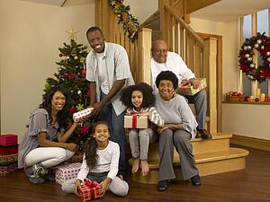 Mixed race family with Christmas tree and gifts