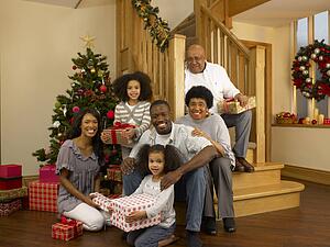 Mixed race family with Christmas tree and gifts