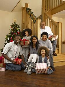 Mixed race family with Christmas tree and gifts