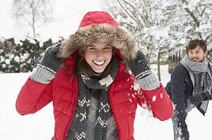 Young couple having snowball fight