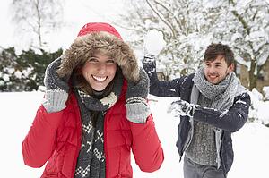 Young couple having snowball fight