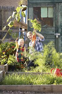 Woman working on allotment with child