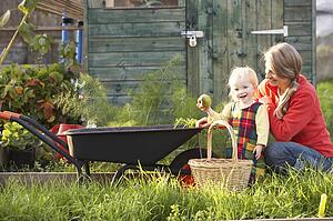 Woman working on allotment with child
