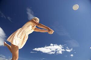 Teenage girl playing beach volleyball