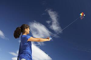 Teenage girl flying a kite