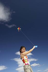 Teenage girl flying a kite