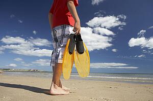 Teenage boy on beach with flippers