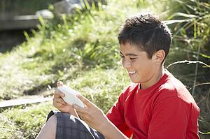 Teenage boy playing with computer game