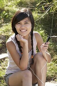 Teenage girl using mp3 player outdoors